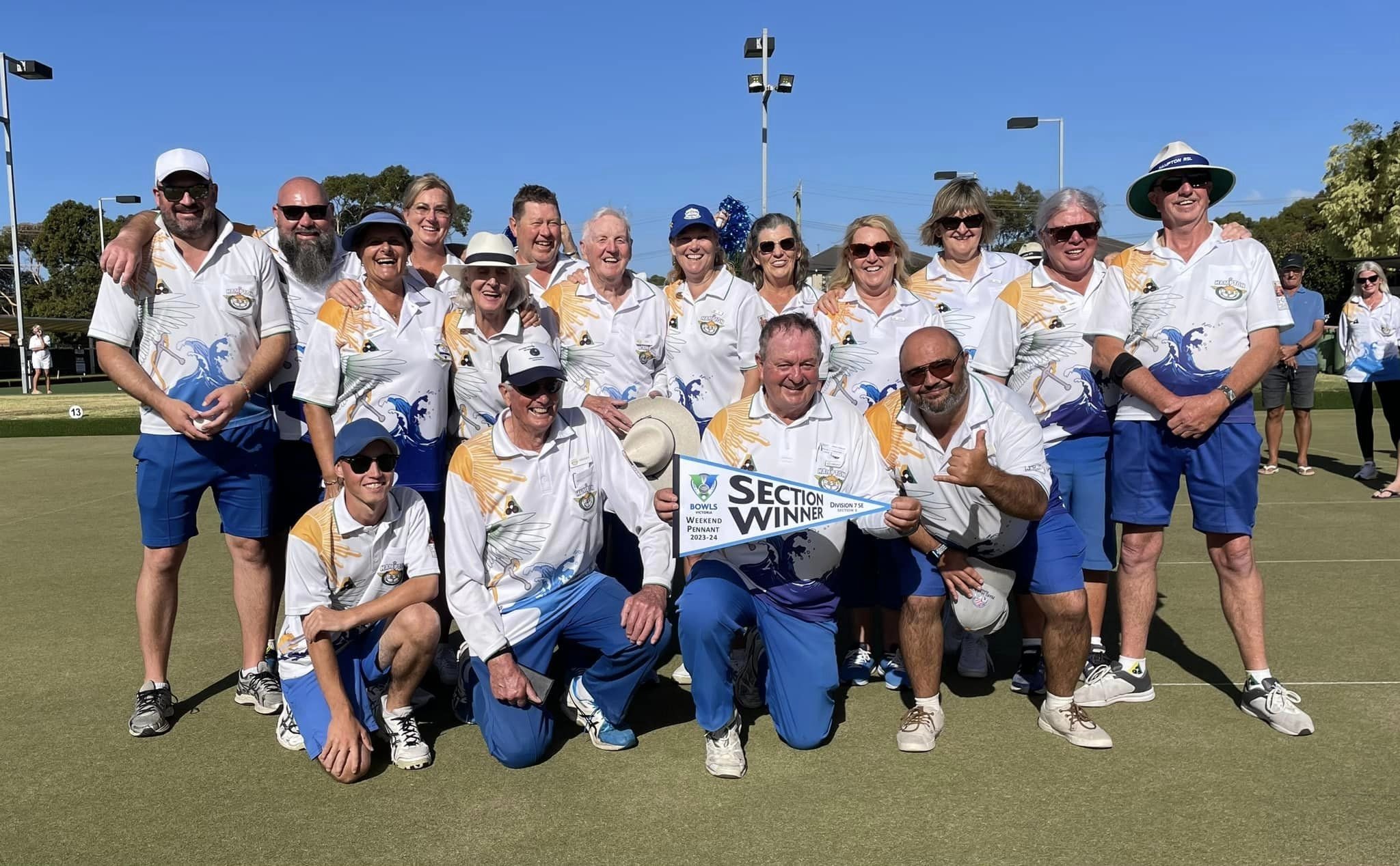 A pennant side holding their section winners banner on the green